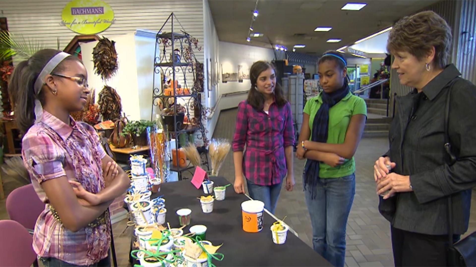 Izzie une fuerzas con Mackenzie y sus amigas, poniendo una tapa en el bote de basura.